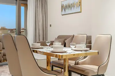 a dining room with a table and chairs at FIRST CLAS 1BR Creek Beach , Lagoon Access in Dubai