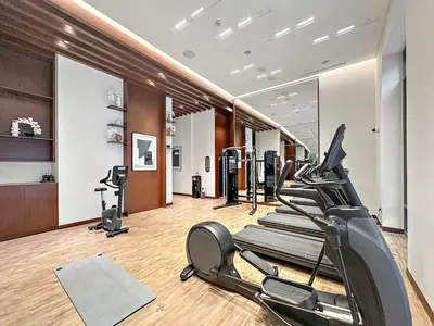 a gym with treadmills and ellipticals in a room at FIRST CLAS 1BR Creek Beach , Lagoon Access in Dubai