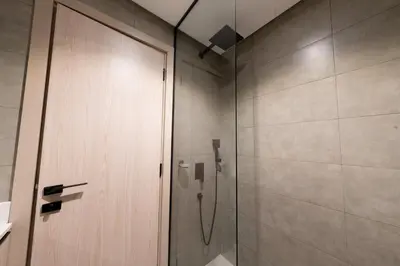 a shower with a glass door in a bathroom at Bright & Stylish 1-Bedroom at Empire Residence in Dubai