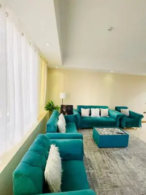 a living room with green couches and a large window at Luxurious 1 Bedroom Apartment in Heart of Dubai in Dubai