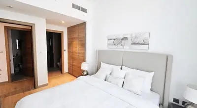 a white bedroom with a white bed with white pillows at Modern New Sea View 1 BR Apartment in Dubai