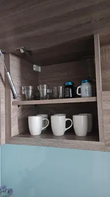 a shelf with cups and other dishes on it at Modern New Sea View 1 BR Apartment in Dubai