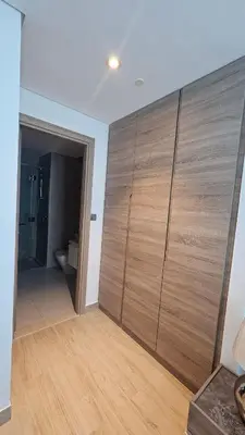 a bathroom with a large wooden closet with a toilet at Modern New Sea View 1 BR Apartment in Dubai