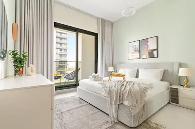 a white bedroom with a bed and a large window at VayK - Prestigious 1BR Apartment in Dubai Hills Estate in Dubai