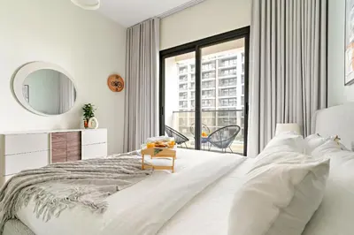 a white bedroom with a large bed and a window at VayK - Prestigious 1BR Apartment in Dubai Hills Estate in Dubai