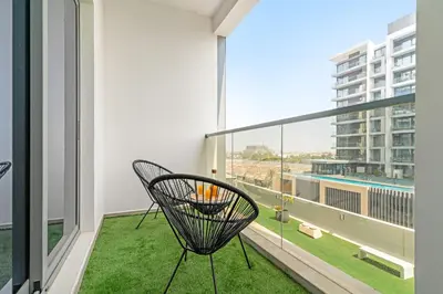 a balcony with a chair and a view of a building at VayK - Prestigious 1BR Apartment in Dubai Hills Estate in Dubai