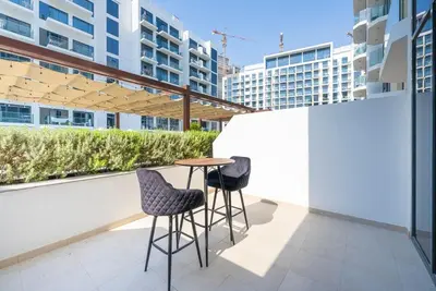 a table and two chairs on a balcony with buildings at Cozy Studio with a huge terrace in Dubai