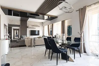 a dining room and living room with a glass table and chairs at Lux Penthouse 4BR Apartment with Iconic Marina Views in Sadaf2 JBR by Simply Comfort in Dubai