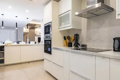 a large white kitchen with white cabinets and appliances at Lux Penthouse 4BR Apartment with Iconic Marina Views in Sadaf2 JBR by Simply Comfort in Dubai