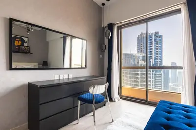 a bedroom with a dresser and a large mirror at Lux Penthouse 4BR Apartment with Iconic Marina Views in Sadaf2 JBR by Simply Comfort in Dubai