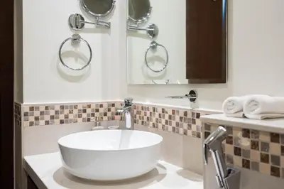 a bathroom with a white sink and a mirror at Reva 1BR - Downtown Living with Burj Khalifa View in Dubai
