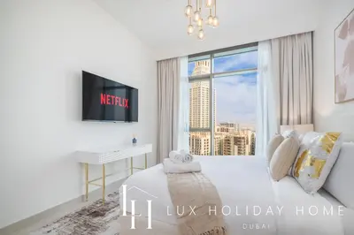 a bedroom with a bed with a desk and a window at LUX The Creek Palace Residence Suite 2 in Dubai