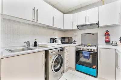 a kitchen with a washing machine and a sink at Bright 1BR with Canal Views Near Burj Khalifa in Dubai