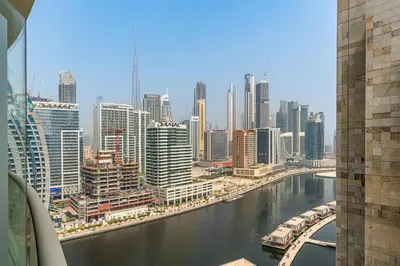 a view of a city with a river and buildings at Bright 1BR with Canal Views Near Burj Khalifa in Dubai