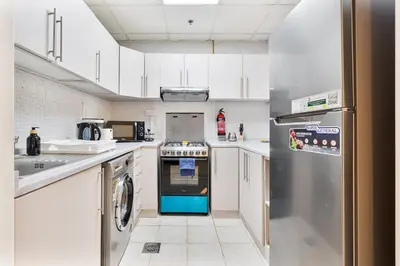 a kitchen with a stove and a refrigerator at Bright 1BR with Canal Views Near Burj Khalifa in Dubai