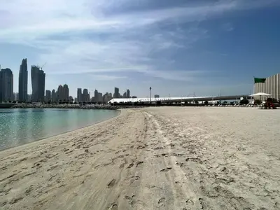 a sandy beach with a city in the background at SettlerHomes - Sunrise Beach Bliss With Private Beach in Dubai