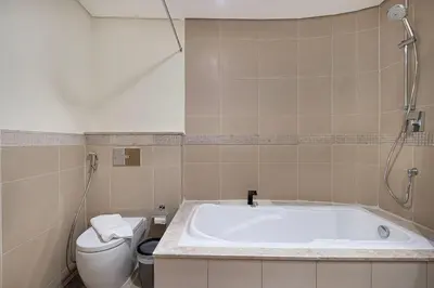 a bathroom with a tub and a toilet at Charming 3BR Sea View 37th Floor in Dubai
