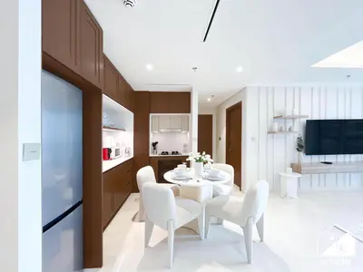 a kitchen and dining room with a white table and chairs at Beachfront 1B at Palm Jumeirah with Balcony & Views in Dubai