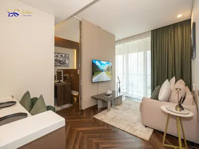 a living room with a couch and a tv at Le Chateau Vacation Homes,Fashion Avenue Residence in Dubai