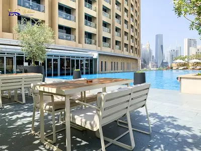 a table and chairs in front of a building at Le Chateau Vacation Homes,Fashion Avenue Residence in Dubai