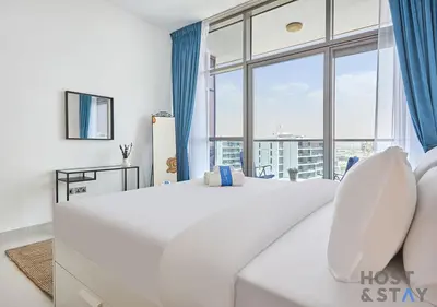 a large white bedroom with a large window at Radiant & Sunny Living - 1BR in ORchid DAMAC Hills in Dubai