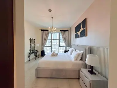 a bedroom with a large bed and a window at Urban Retreat 1BR with Pool & Burj Glimpse in Dubai