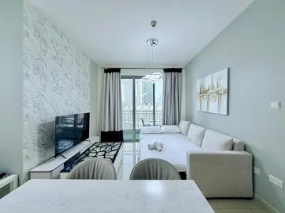 a living room with a couch and a table at Urban Retreat 1BR with Pool & Burj Glimpse in Dubai