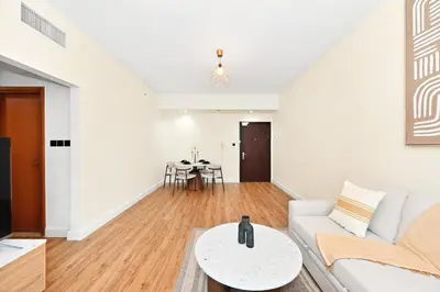a living room with a white couch and a table at Luxury 2BR Marina View-walking distance to JBR beach, marina mall & metro in Dubai