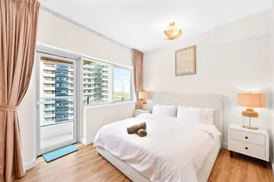 a bedroom with a white bed and a large window at Luxury 2BR Marina View-walking distance to JBR beach, marina mall & metro in Dubai