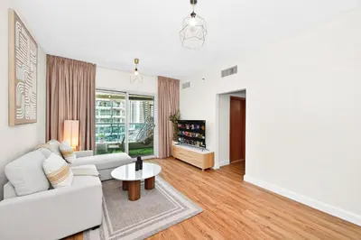 a living room with a white couch and a table at Luxury 2BR Marina View-walking distance to JBR beach, marina mall & metro in Dubai