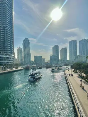 a boat in a river in a city with buildings at AquaVista Ensuite Room - Lakeview in Dubai