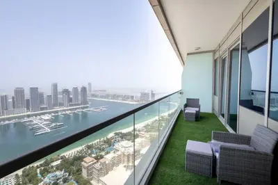 a balcony with chairs and a view of the water at Luxuries Sky View Apartment in Dubai