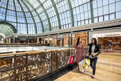 two women walking in a shopping mall at Walk to JBR Marina Beach & Tram! Luxury Family 3BD, Stunning Views in Dubai