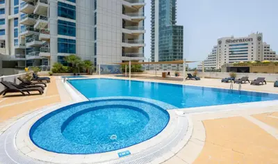 a large swimming pool in the middle of a building at Walk to JBR Marina Beach & Tram! Luxury Family 3BD, Stunning Views in Dubai