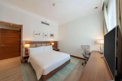 a bedroom with a bed and a desk and a television at Hilton Garden inn Dubai Jumeirah in Dubai