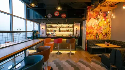 a restaurant with a bar with chairs and a counter at Hilton Garden inn Dubai Jumeirah in Dubai