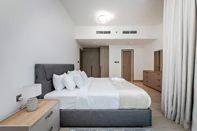 a bedroom with a large bed with white sheets at Elegant 1BR Apartment Me Do Re Tower in JLT in Dubai
