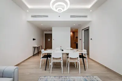 a dining room with a white table and chairs at Elegant 1BR Apartment Me Do Re Tower in JLT in Dubai