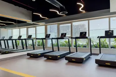a gym with a row of rows of exercise equipment at Elegant 1BR Apartment Me Do Re Tower in JLT in Dubai