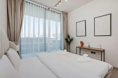 two beds in a room with a large window at Inviting 1BR Apartment in JVC in Dubai