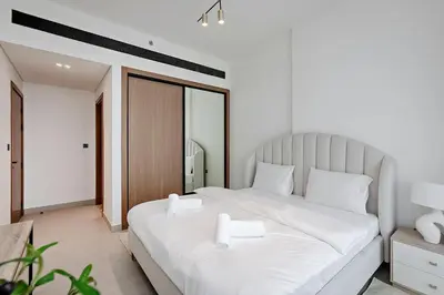 a bedroom with a large white bed with white pillows at Inviting 1BR Apartment in JVC in Dubai