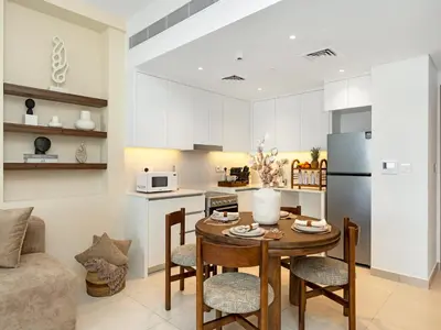 a kitchen and living room with a table and chairs at Modern Jumeirah Apartment Near Beach in Dubai