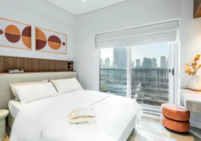 a bedroom with a white bed and a large window at Luxury Lakeview Escape in Dubai
