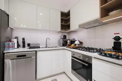 a kitchen with white cabinets and a stove top oven at Exquisite 2BR Apartment near Dubai Mall, Downtown Dubai in Dubai