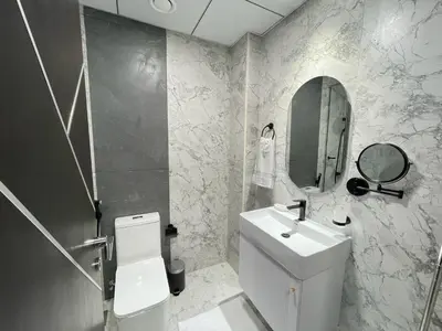 a bathroom with a toilet and a sink and a mirror at Cosy Studio in Opalz by Danube, Al Barsha South in Dubai