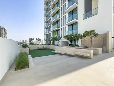 an apartment patio with two benches and a lawn at Minutes from Circle Mall, Grocery Stores & Bus Stop 2BR with Mini Private Pool on Balcony, Binghatti Tulip, Jumeirah Village Circle by Deluxe Holiday Homes in Dubai