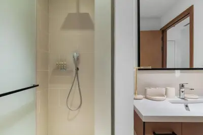 a bathroom with a shower and a sink at Novity Signature Homes in Dubai