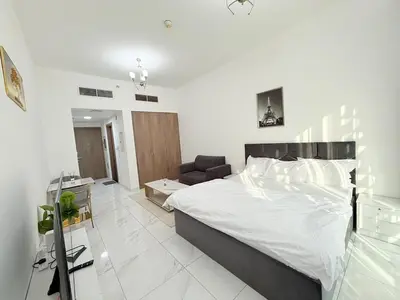 a white bedroom with a large bed and a couch at A place like home in Dubai