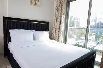 a bedroom with a large bed and a large window at Stunning Studio Apartment in Jvc in Dubai