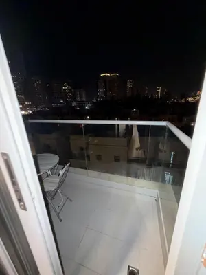 a balcony with a view of a city at night at Stunning Studio Apartment in Jvc in Dubai